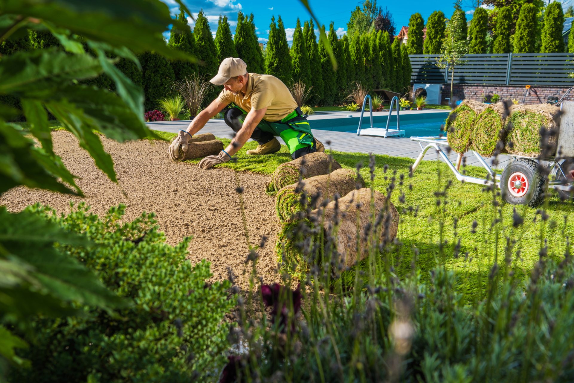 Caucasien dans la quarantaine pour restaurer les gazon résidentiels résidentiels de jardin pendant l'entretien du printemps.